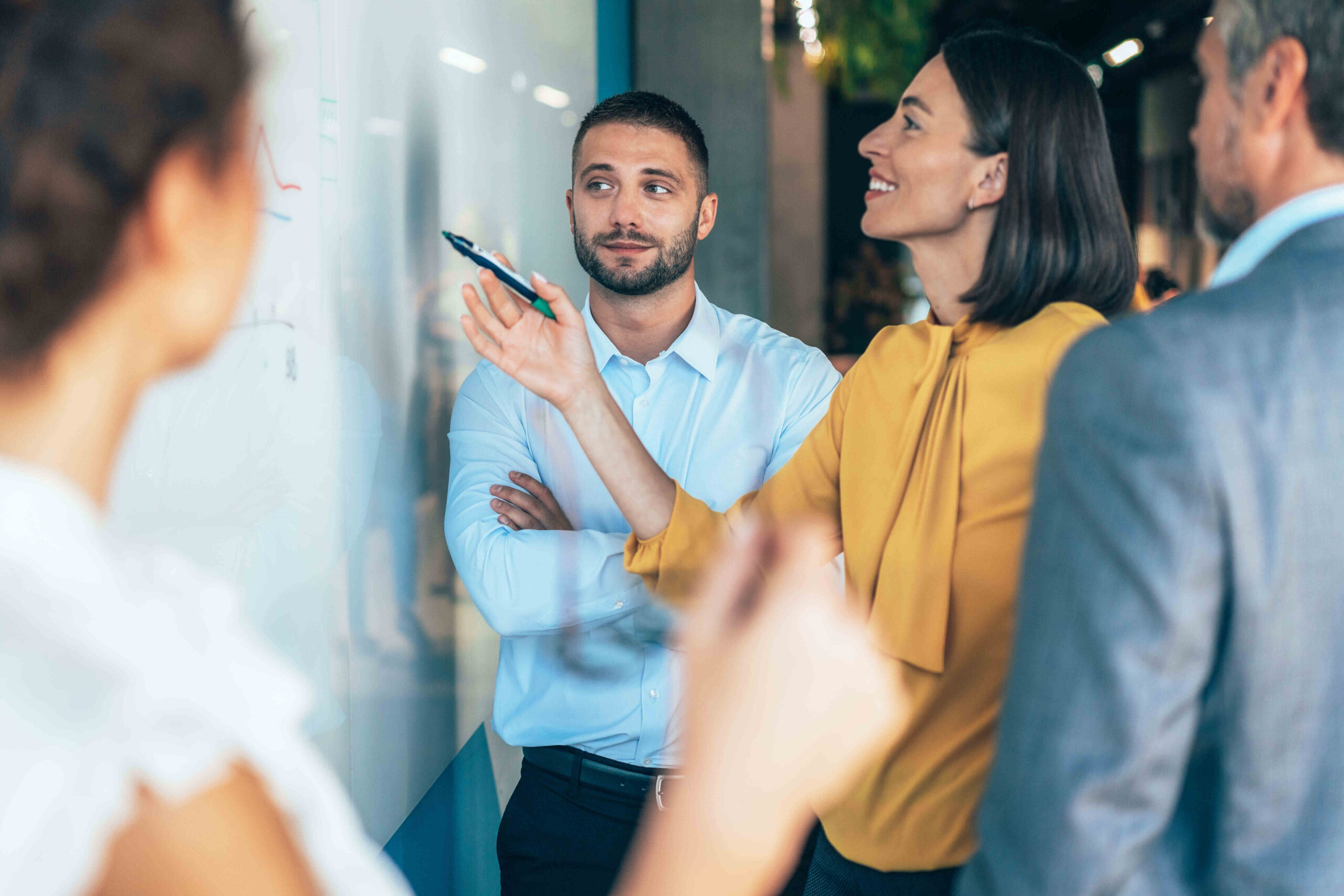 A group of coworkers collaborating on a whiteboard